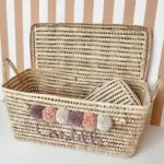Personalized Moroccan Chest with Pompoms – Handwoven Palm Leaf Storage Trunk in Lilac, Vintage Pink & Beige