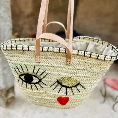 87112093e0ea2a1807a90b231cbbfbd894ef7b1629e732504b357dffe69891f0-1.webp Wink Basket – Handwoven Palm Fiber Tote with Wool & Sequin Embroidery