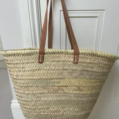 e6b2fe1d3f7d8fffc26ea1350f0d397dbe7e3b1b1dada84decb1da6fc07914ab-1.webp Emma French Style Basket – Handwoven Palm Leaf Tote with Leather Handles