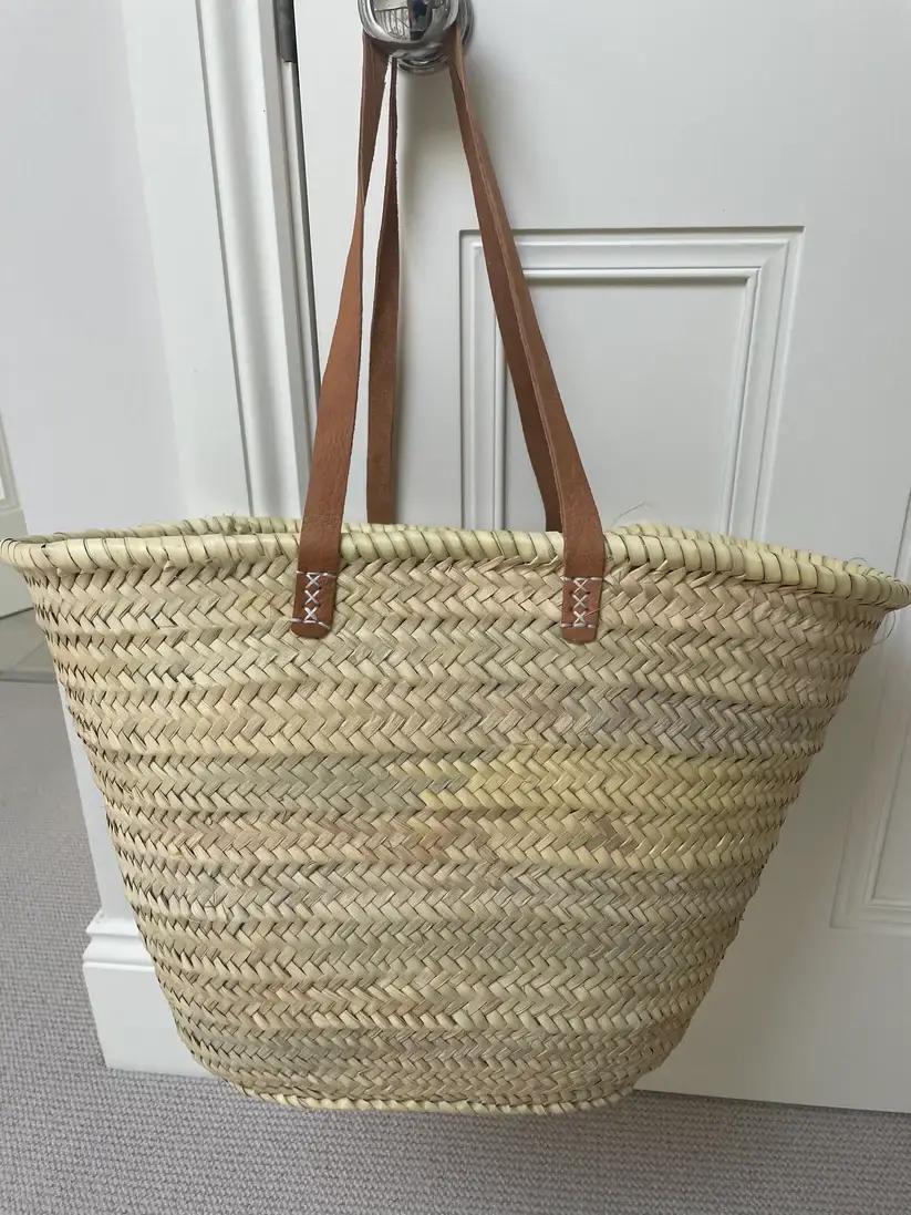 e6b2fe1d3f7d8fffc26ea1350f0d397dbe7e3b1b1dada84decb1da6fc07914ab-1.webp Emma French Style Basket – Handwoven Palm Leaf Tote with Leather Handles