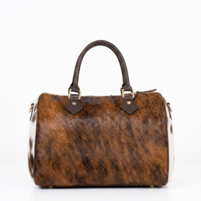 Handmade cowhide leather barrel bag in brown and white hair-on-hide, with dark leather handles and gold hardware, western style Boston satchel
