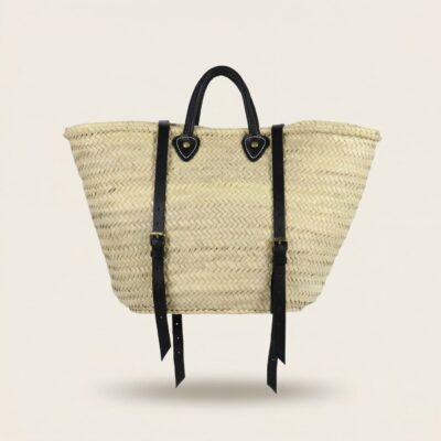 Handwoven Moroccan palm leaf straw market tote with braided leather top handles and convertible leather backpack straps with silver buckles on white surface