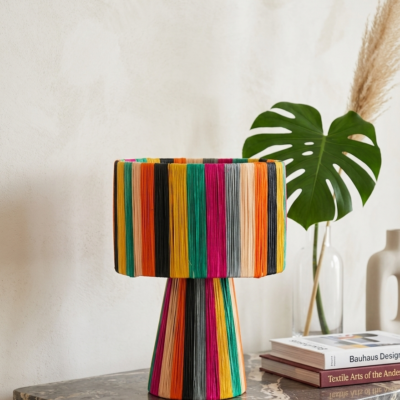 Handmade Moroccan multicolor raffia mushroom table lamp with bold rainbow stripes in teal, yellow, orange, fuchsia, black and grey, wide drum shade on tapered cone base