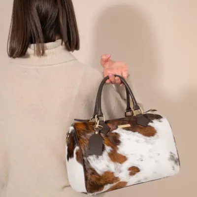 Back view of large cowhide leather barrel bag showing rich brown hair-on-hide texture, western style handbag